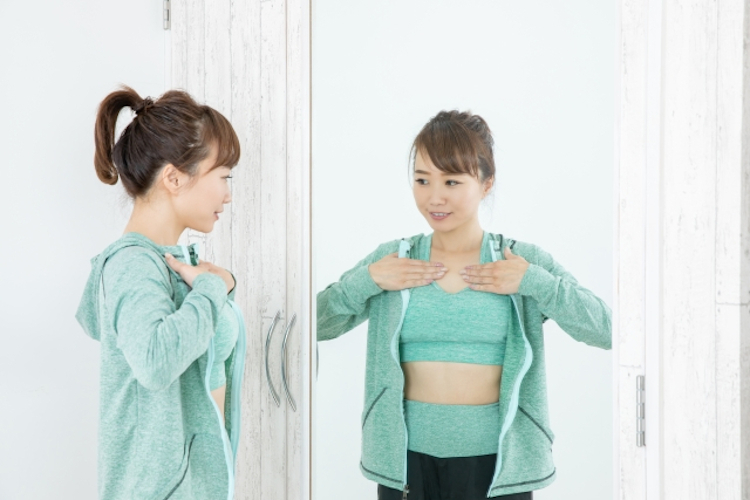 鏡で体型を気にする女性