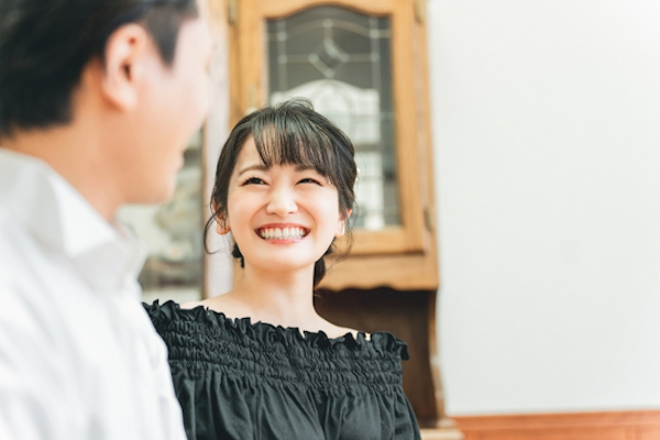異性と対面して笑顔を見せる女性