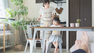 子供の面倒をみながら食事を作る女性