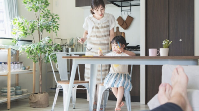 子供の面倒をみながら食事を作る女性