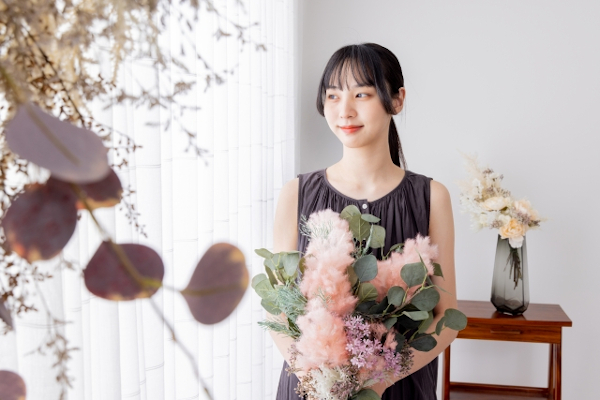 部屋の中に花を飾る女性