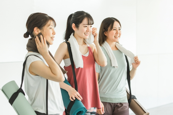 友達とヨガを習いに行く女性