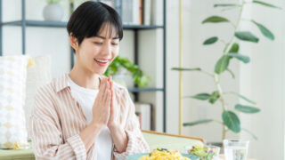 食事を前に手を合わせる女性