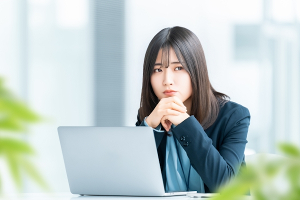 パソコンの画面を見ながら悩んでいる女性