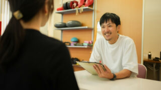 パーソナルトレーナーとカウンセリングを受ける女性
