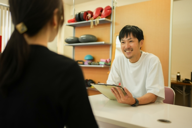 パーソナルトレーナーとカウンセリングを受ける女性