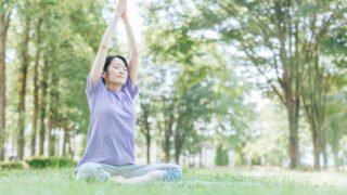 ストレッチしながら呼吸法をする女性