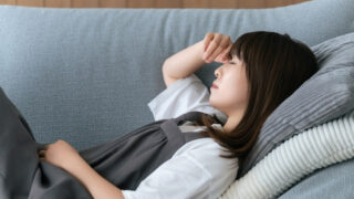 疲れてソファーで寝る女性