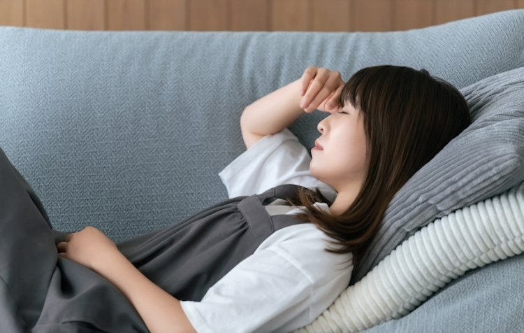 疲れてソファーで寝る女性