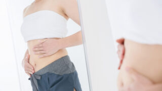お腹の肉を確認する女性