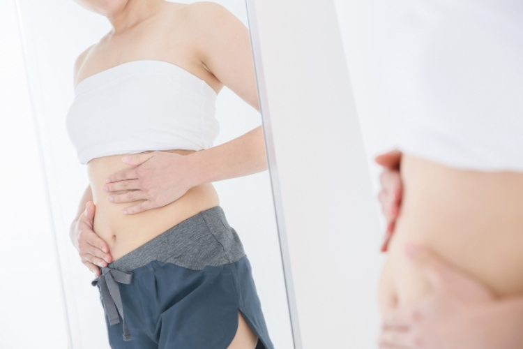 お腹の肉を確認する女性