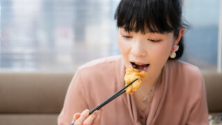 唐揚げを食べる女性