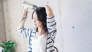 お風呂上りに髪を乾かす女性
