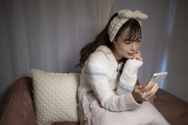 夜スマホを見る女性