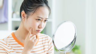 自信なく鏡を見る女性
