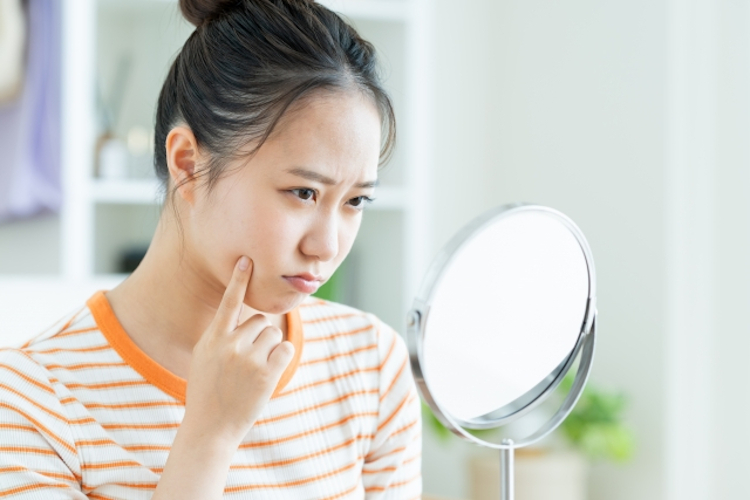 自信なく鏡を見る女性