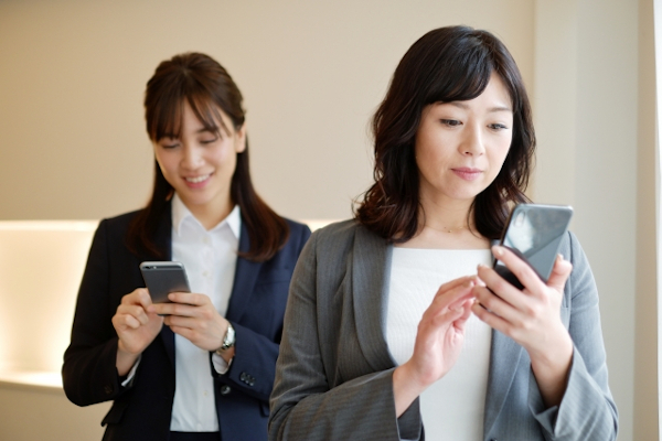 スマホ猫背で眺める女性