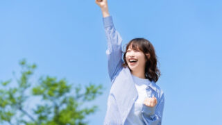 青空の下、楽しそうにする女性