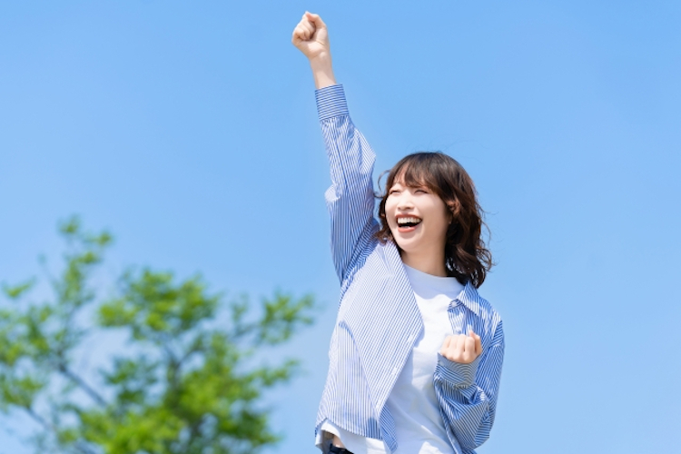 青空の下、楽しそうにする女性