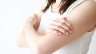 腕の筋肉痛を気にする女性