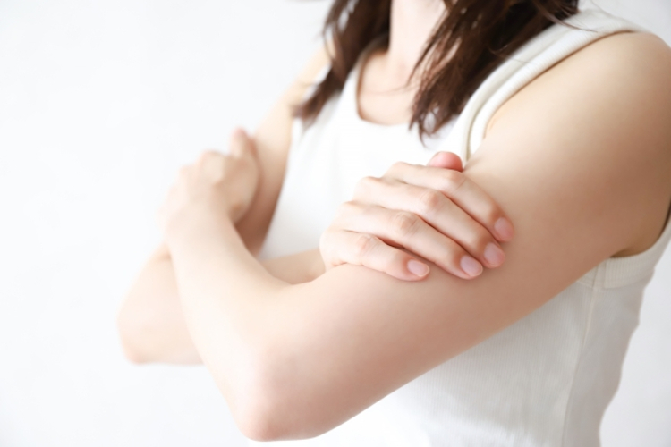 腕の筋肉痛を気にする女性