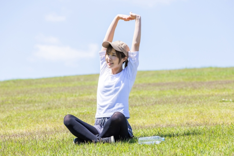 外でストレッチする女性