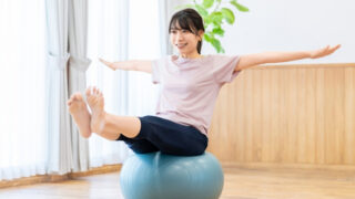 自宅でバランスボールにのる女性