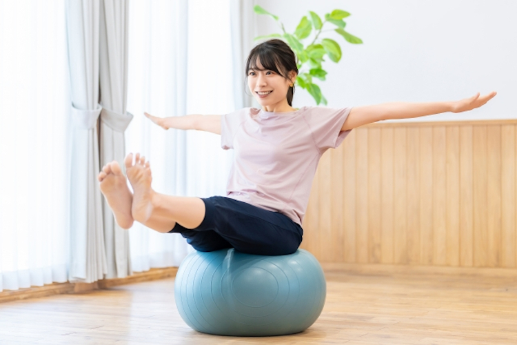 自宅でバランスボールにのる女性