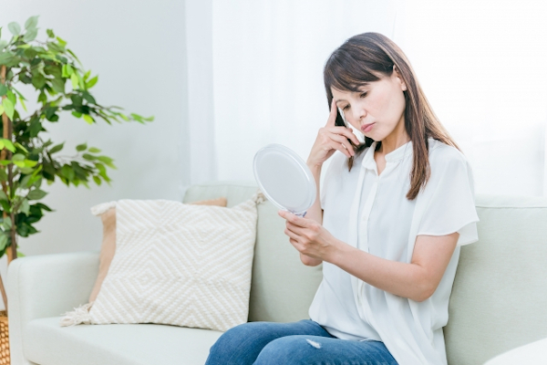 鏡を見て悩む40代女性