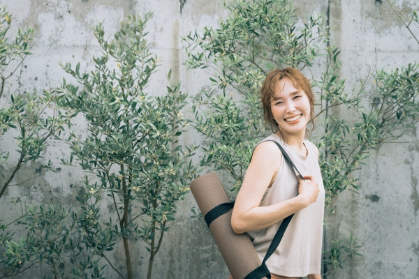 ヨガマットを持つ40代女性
