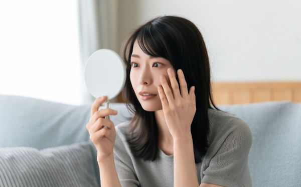 鏡で肌を気にする女性