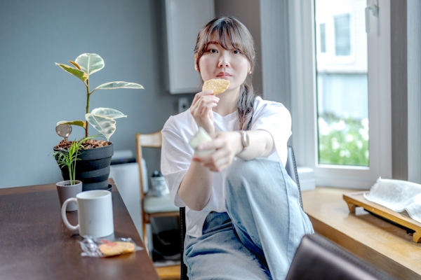 自宅でお菓子を食べる女性