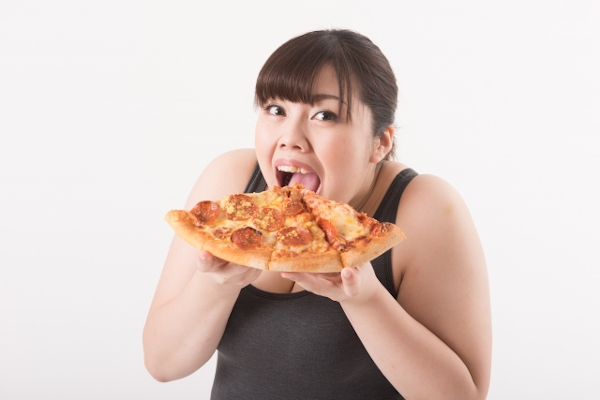 ピザを食べる太った女性