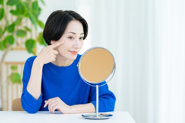 鏡で肌を気にする40代女性