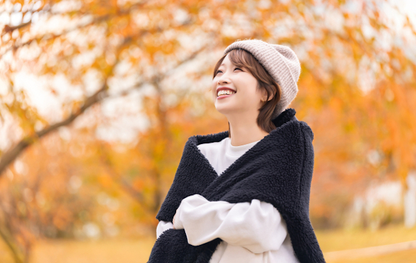 紅葉の中を散歩する女性
