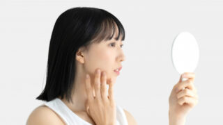 手鏡で顔を気にする女性