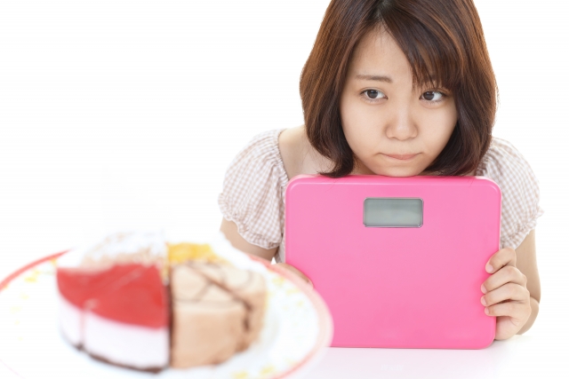 甘いものを我慢する女性