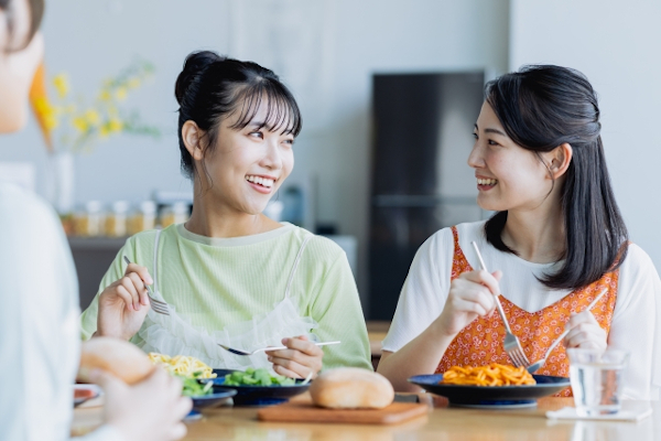 友人と食事する女性