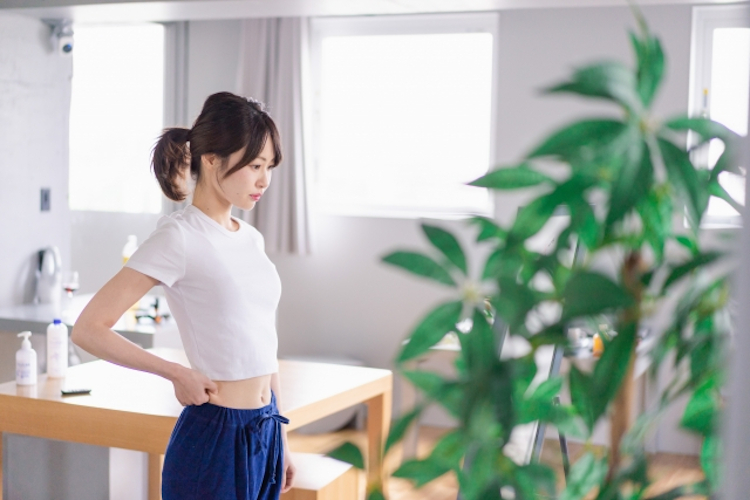 鏡で体型を気にする女性