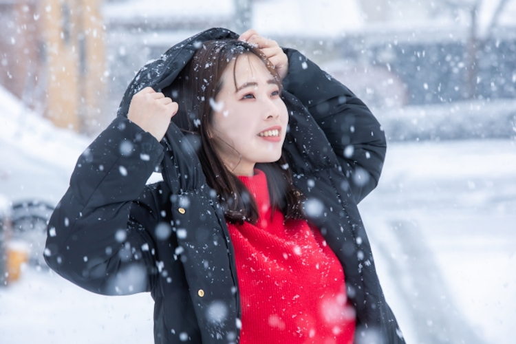 雪降る日に出かける女性
