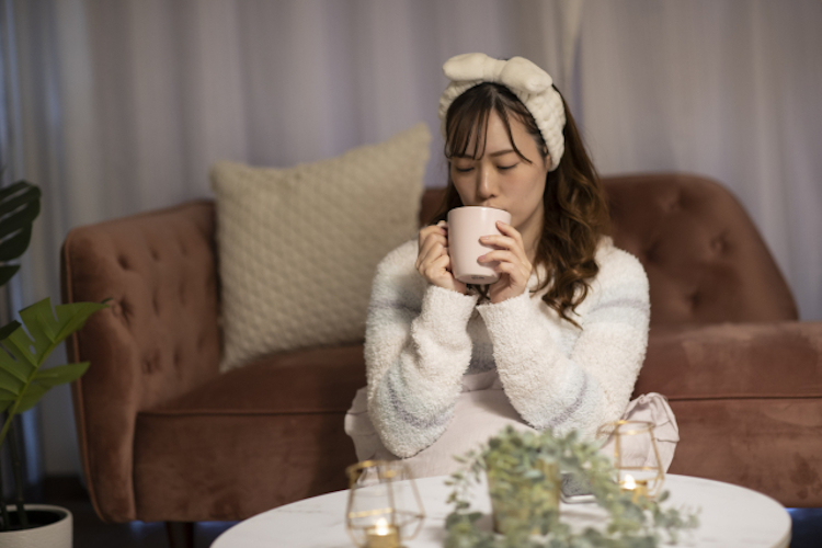 夜に温かい物を飲む女性