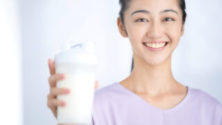 プロテインを持って笑顔の女性