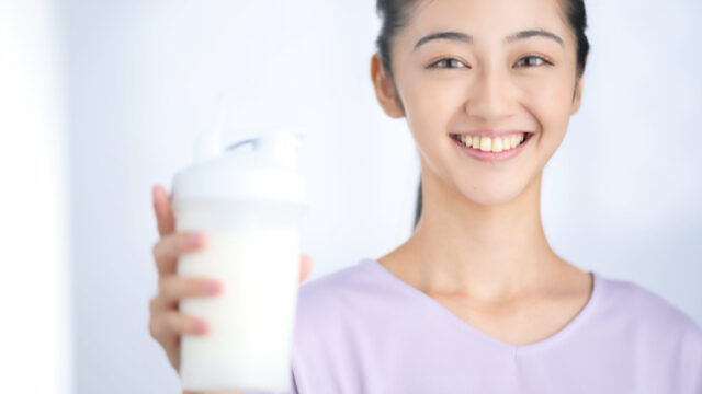 プロテインを持って笑顔の女性