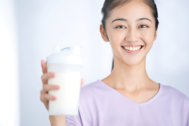 プロテインを持って笑顔の女性