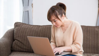 猫背でパソコンを操作する女性