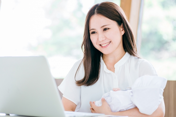 赤ちゃん抱きながらPC触る女性