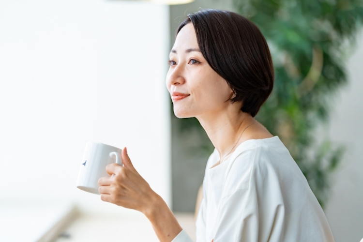 自宅でお茶を飲む瘦せている女性