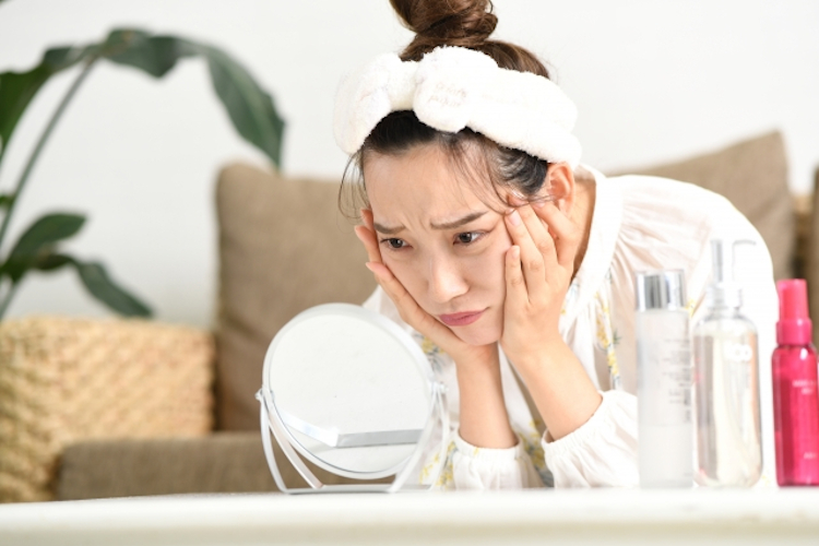 顔の肉を気にする女性