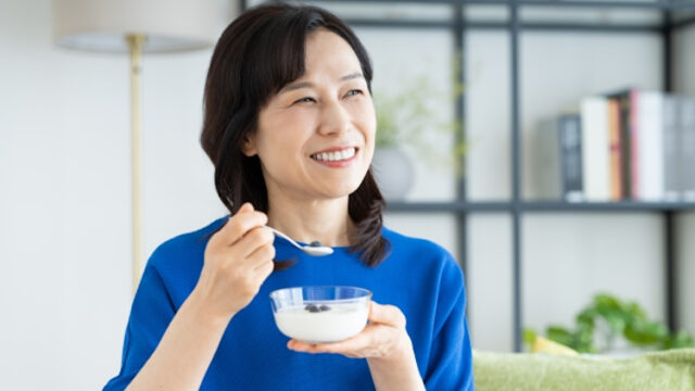 ヨーグルトを食べる50代女性