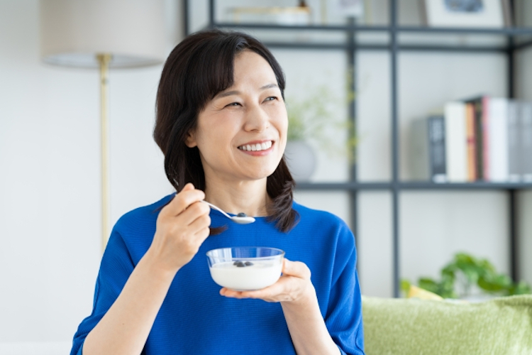 ヨーグルトを食べる50代女性